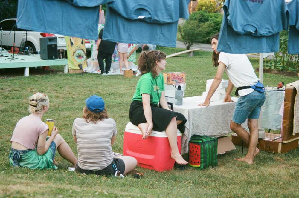 festival hydration station, people filling water bottles, Lollapalooza festival grounds, summer festival attendees, staying cool, free water access}