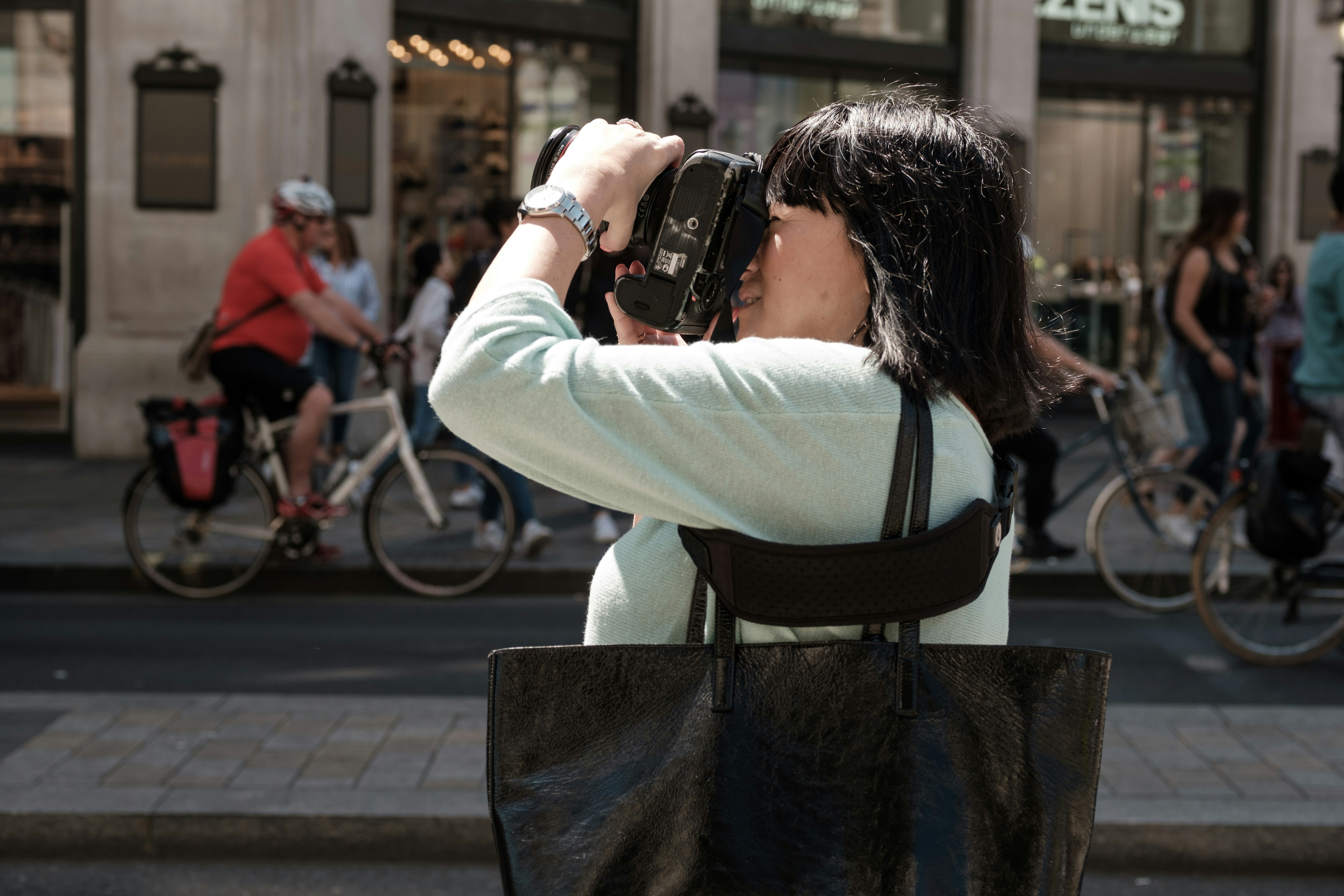 woman traveler, walking purposefully, city crowd, aware, crossbody bag, looking around, street photography