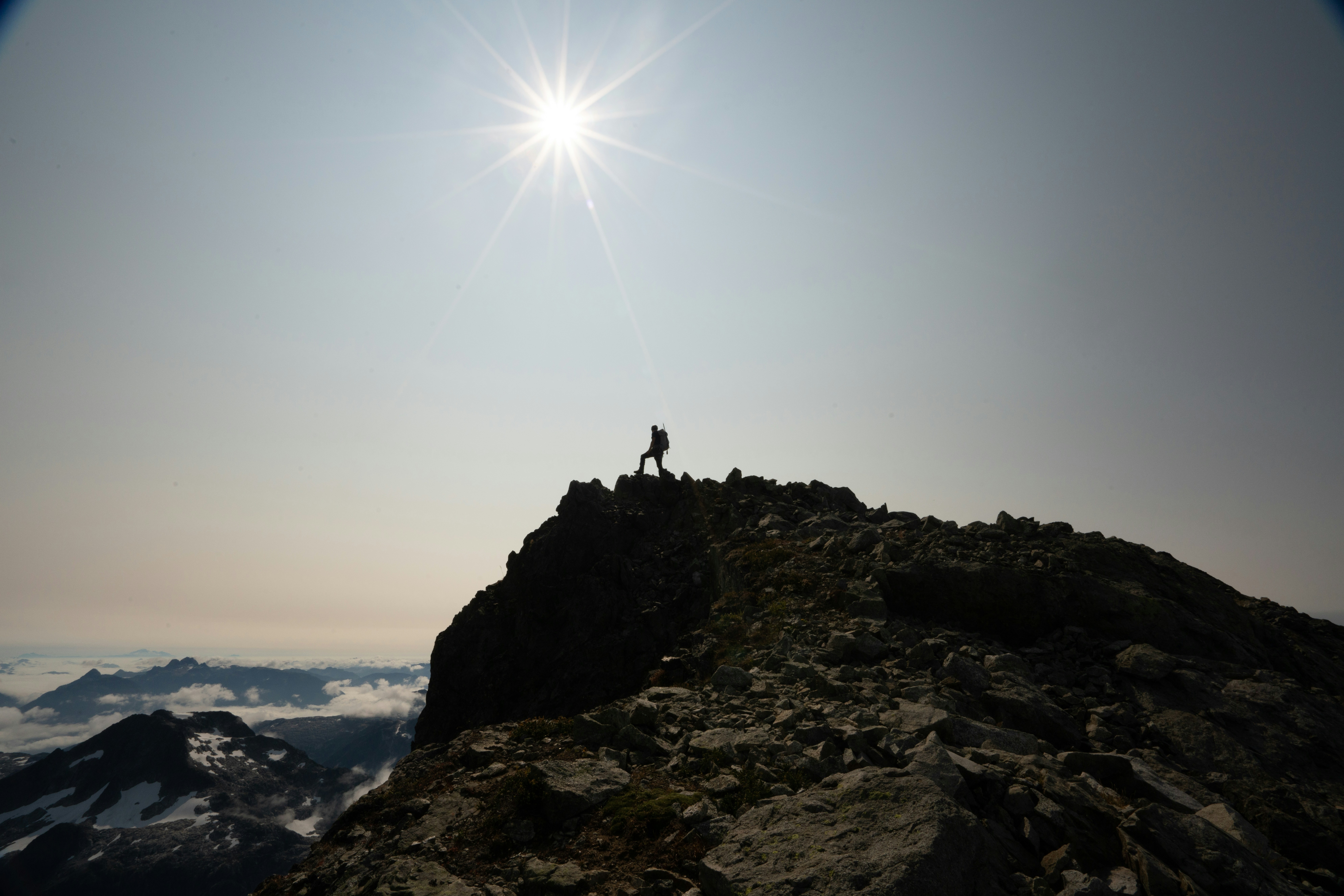 hiker on mountain summit, epic landscape, sunrise, misty mountains, sense of achievement, solo traveler, vast wilderness