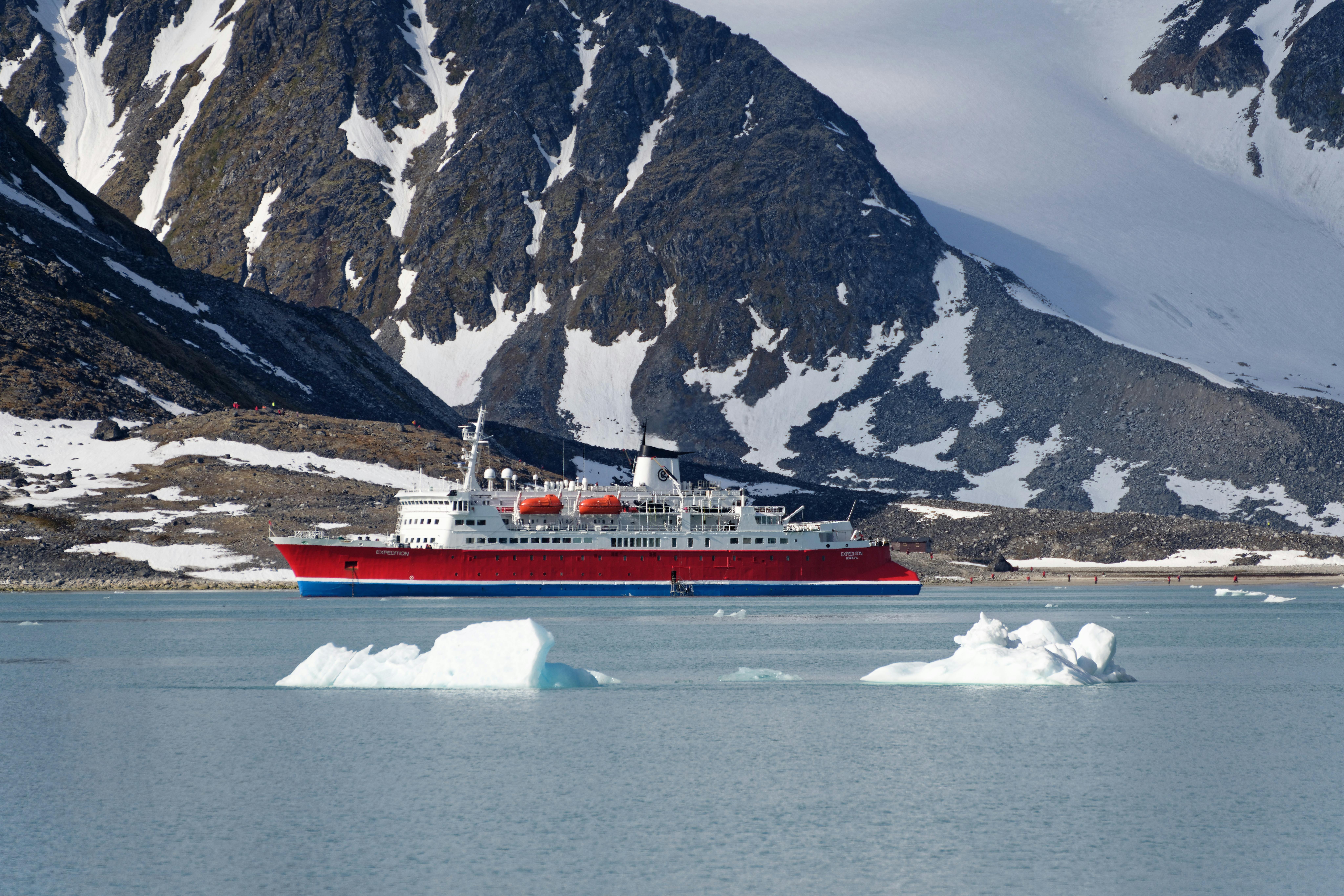 kayaker in Antarctica, paddling among icebergs, blue ice, expedition cruise ship, calm water, polar adventure, dramatic landscape
