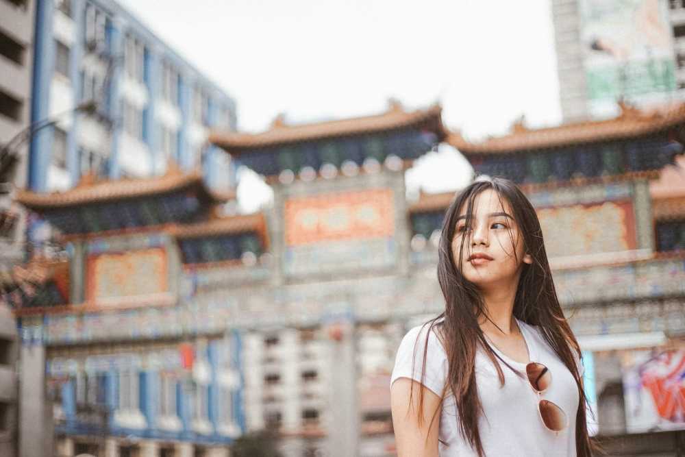 solo female traveler, walking confidently, city street, crossbody bag, aware, street style, daytime