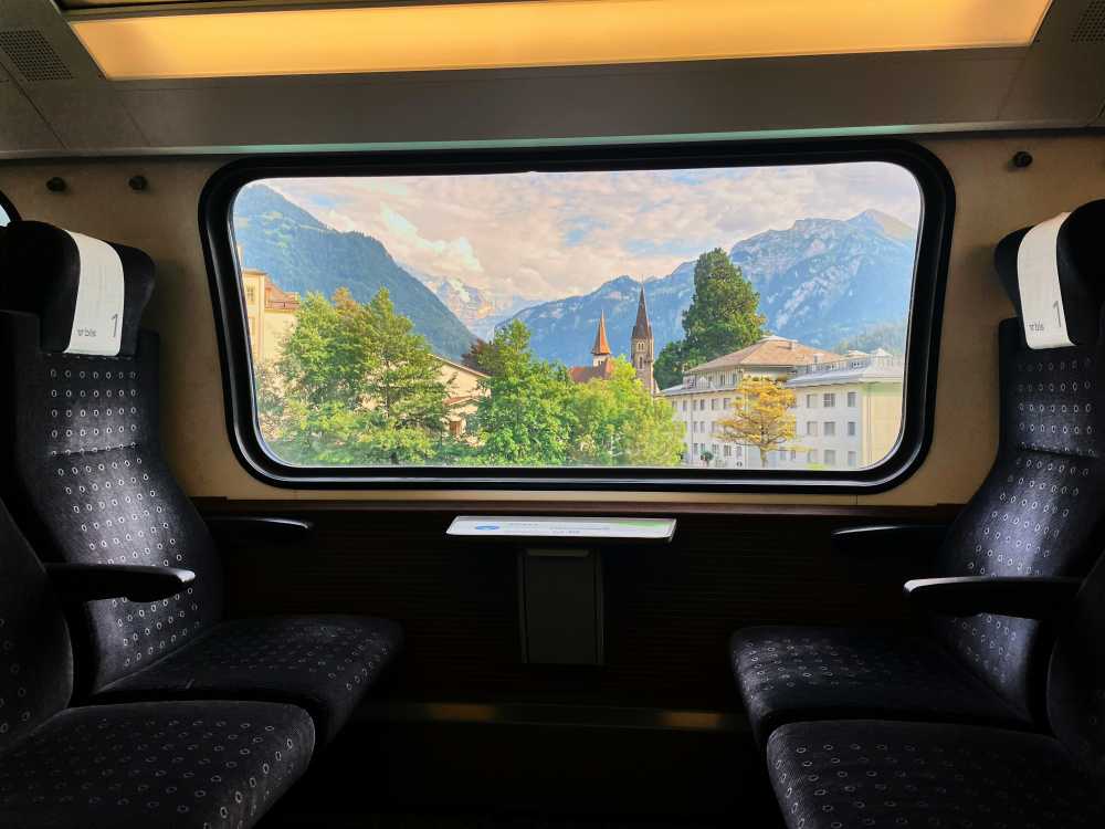 woman looking out train window, European landscape, high-speed train, scenic view, solo journey, reflective